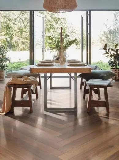 Elegant dining room featuring dark wood-look luxury vinyl flooring in a chevron pattern.