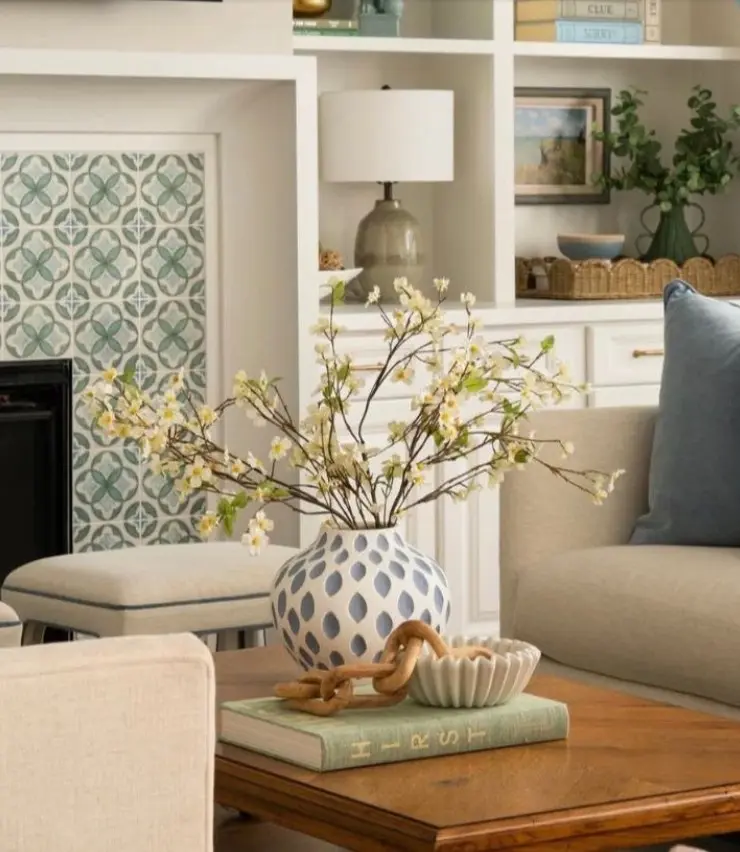 Decorative fireplace surround featuring patterned green and white cement-style tiles in a bright, modern living room.