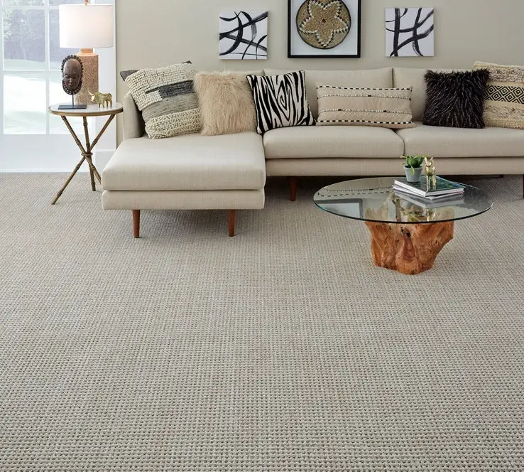 Modern living room with a neutral, textured loop-pile carpet and a cream-colored sectional sofa.